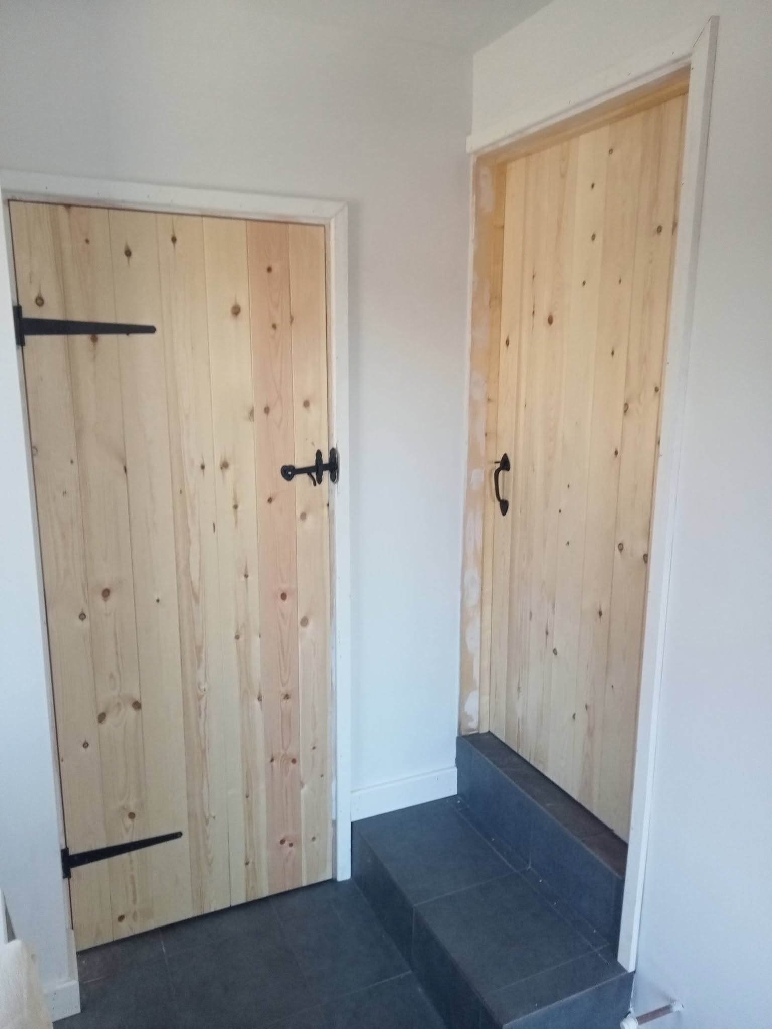 Handmade ledge and brace wooden doors with black ironmongery